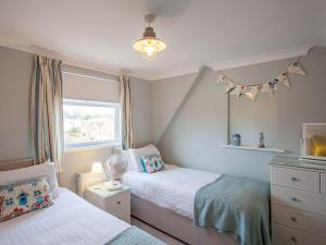 a small bedroom with two beds and a window at The Castleton in Swanage