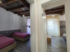 een slaapkamer met 2 bedden met paarse lakens en houten vloeren bij SDL luxury home Al Pavone in Viterbo