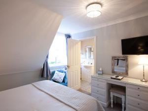a bedroom with a bed and a desk and a television at The Castleton in Swanage