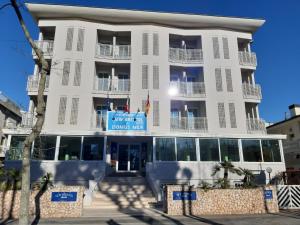 a white building with a sign on it at New Bristol Sport Hotel in Cesenatico