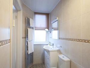 a bathroom with a toilet and a sink and a window at The Castleton in Swanage