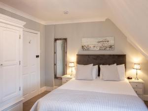 a bedroom with a large white bed with two lamps at The Castleton in Swanage