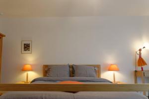 - une chambre avec un grand lit et deux lampes dans l'établissement Studio Les Terrasses de Kerangall, à Brest