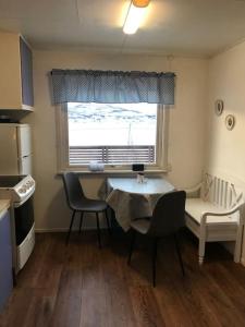 a kitchen with a table and chairs and a window at Trivelig fritidshus på Årnes, Senja in Straumstad