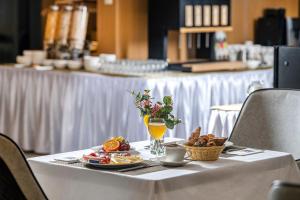 stół z talerzem jedzenia i soku pomarańczowego w obiekcie Willis Hotel Business & Wellness w mieście Zalaegerszeg