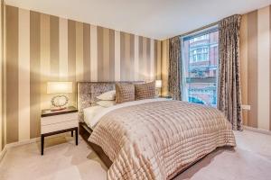 1 dormitorio con cama y ventana en The Buckingham Royal, en Londres