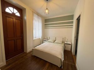 1 dormitorio con cama, ventana y puerta en Centre ville - Maison chaleureuse - 6 pers en Châteaubriant