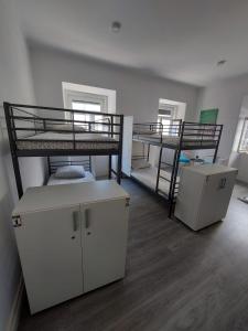 a room with two bunk beds and a desk at Aloha Hostel in Portimão