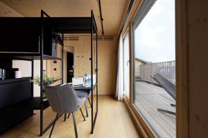 a room with a desk and a balcony at numa l Wood Rooms & Apartments in Vienna