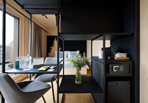 Zimmer mit einem Schreibtisch mit Stühlen und einem Tisch mit Blumen in der Unterkunft numa l Wood Rooms & Apartments in Wien