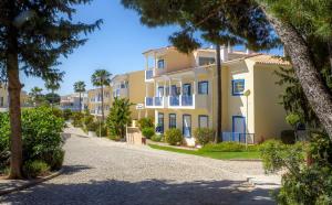 a street in front of a building with trees at ALFELI-AP in Olhos de Água