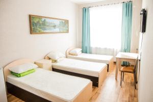 a small room with three beds and a window at Hotel Rubin in Leninogorsk