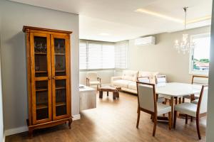 a living room with a table and a couch at Apartamento moderno no Vale dos Vinhedos in Monte Belo