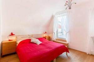 a bedroom with a red bed and a window at Gästesuiten beim Schloss in Eisenstadt