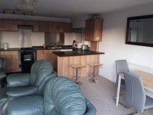 a living room with a couch and a kitchen at RentUnique Spinney SpaciousSuper Snug 1 bed home. in Ifield