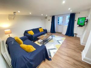 ein Wohnzimmer mit zwei blauen Sofas und einem TV in der Unterkunft Westons Hideaway, 2 Bed, Free Parking, 6 mins walk to beach, in Weston-super-Mare