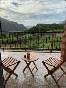 a table and two chairs on a balcony with a view at Green Discovery B&B Tamarind Falls 7 Cascades in Henrietta