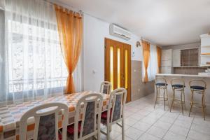 eine Küche mit einem Tisch und Stühlen im Zimmer in der Unterkunft Apartments Belle Vue in Stanići
