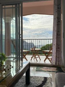 a balcony with a table and a view of the mountains at Green Discovery B&B Tamarind Falls 7 Cascades in Henrietta