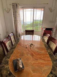 a dining room with a wooden table and chairs at Green Discovery B&B Tamarind Falls 7 Cascades in Henrietta