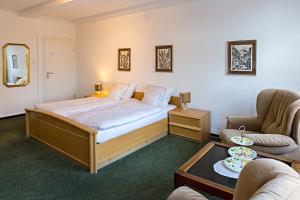 een slaapkamer met een bed en 2 stoelen en een tafel bij Altenceller Tor, Hotel & Restaurant in Celle