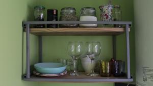 a shelf with wine glasses and plates and other items at La Tiny House in Ushuaia