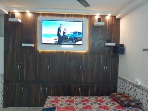 德奧加爾的住宿－CHINTA HARAN REST HOUSE，挂在墙上的平面电视