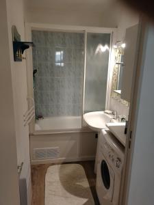 a bathroom with a tub and a sink and a toilet at Appartement 2 pièces pour 4 personnes avec vue mer in Saint-Hilaire-de-Riez