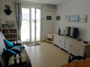 uma sala de estar com um sofá e uma televisão em Appartement 2 pièces pour 4 personnes avec vue mer em Saint-Hilaire-de-Riez