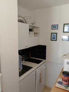 uma cozinha com um lavatório e um fogão forno superior em Appartement 2 pièces pour 4 personnes avec vue mer em Saint-Hilaire-de-Riez