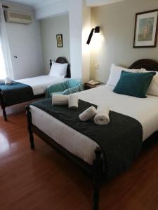 two beds in a hotel room with towels on them at Hotel Termas in Chaves