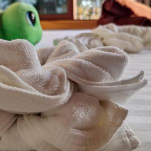 uma pilha de toalhas brancas sobre uma mesa em Cowry Inn em Fulidhoo