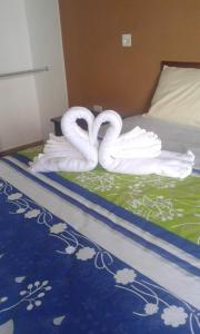 dos cisnes están sentados en la parte superior de una cama en The Lookout Beach Hotel, en San Lorenzo
