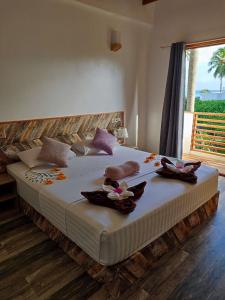 a bedroom with a large bed with towels on it at Cowry Inn in Fulidhoo