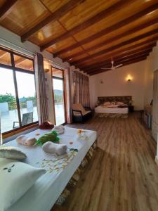 a bedroom with two beds in a room with windows at Cowry Inn in Fulidhoo