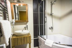 a bathroom with a sink and a tub and a mirror at Berlin Hotel Nisantasi in Istanbul