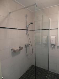 a shower with a glass door in a bathroom at Strandhotel de Horn in Callantsoog