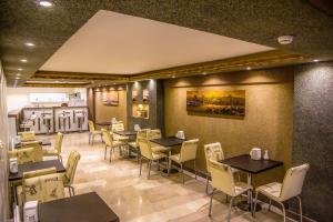 a restaurant with tables and chairs and a kitchen at Berlin Hotel Nisantasi in Istanbul