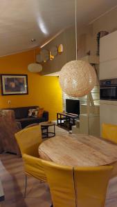 - un salon avec une table et des chaises jaunes dans l'établissement Vakantiehuis Amber, à Simpelveld