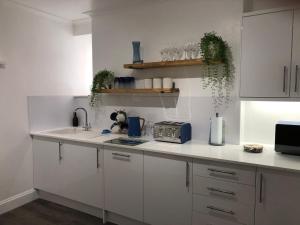 a kitchen with white cabinets and a counter top at Bank Place in Falmouth