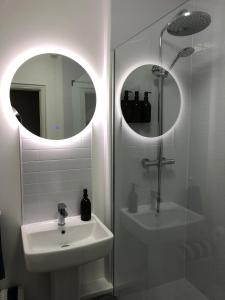 a bathroom with a sink and a shower and a mirror at Bank Place in Falmouth