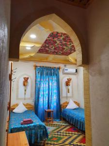 um quarto com duas camas num quarto com um arco em Zukhro Boutique Hotel em Khiva
