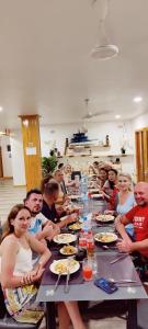 a group of people sitting at a long table eating at Cowry Inn in Fulidhoo +33 photos