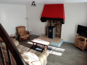 a living room with a couch and a fireplace at Craftycotta in Glomel