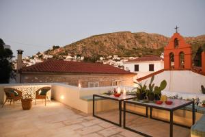 a rooftop patio with a view of a city at Cactus Hydra - Art Apartments in Hydra