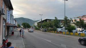 a city street with a car driving down the street at Rooms Vedran in Mostar