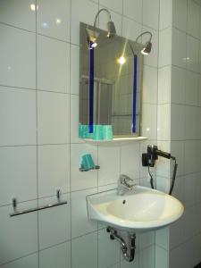 a white bathroom with a sink and a mirror at Hotel - Restaurant Braustube in Haaren +40 photos