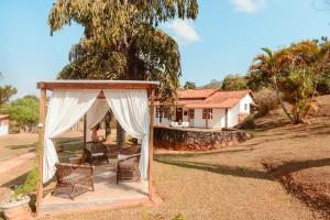 a gazebo with chairs in front of a house at Pouso dos Querubins in Tiradentes