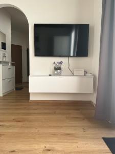 a living room with a large television on a wall at living Appartement in Flachau