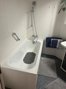 a bathroom with a bath tub with a shower at living Appartement in Flachau